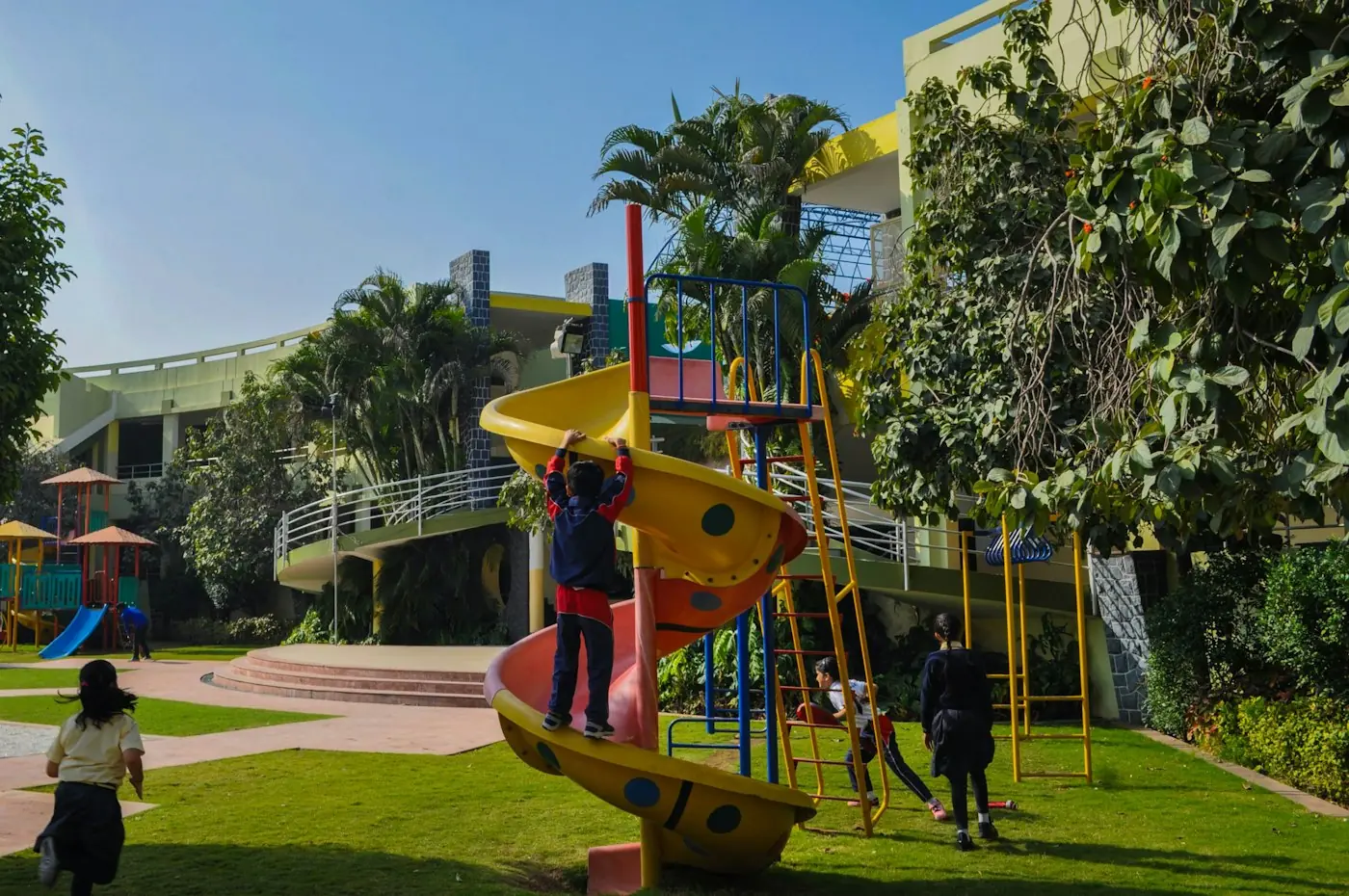 A green school campus with a playground and children at play.